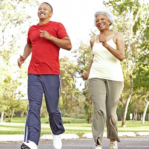 An older couple jogs in the park