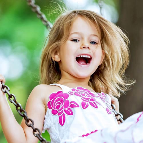 A girl smiles while swinging
