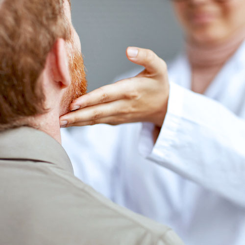 A doctor places his hand under a patient