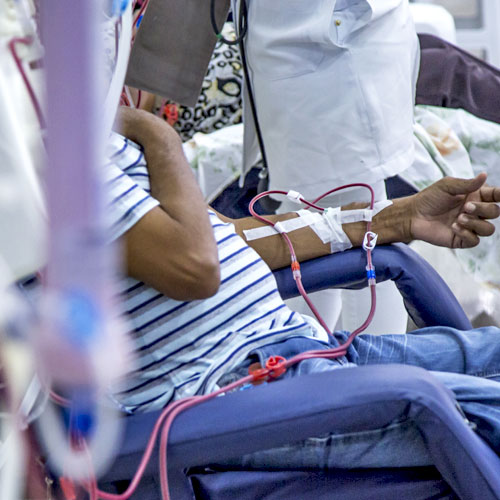 A patient with kidney failure sits in a chair while undergoing dialysis