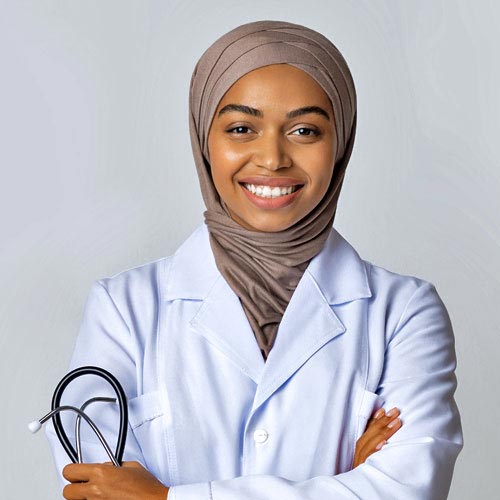 A smiling female doctor in a white lab coat holds a stethoscope in her right hand