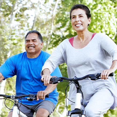A man and a woman smiling while riding bicycles